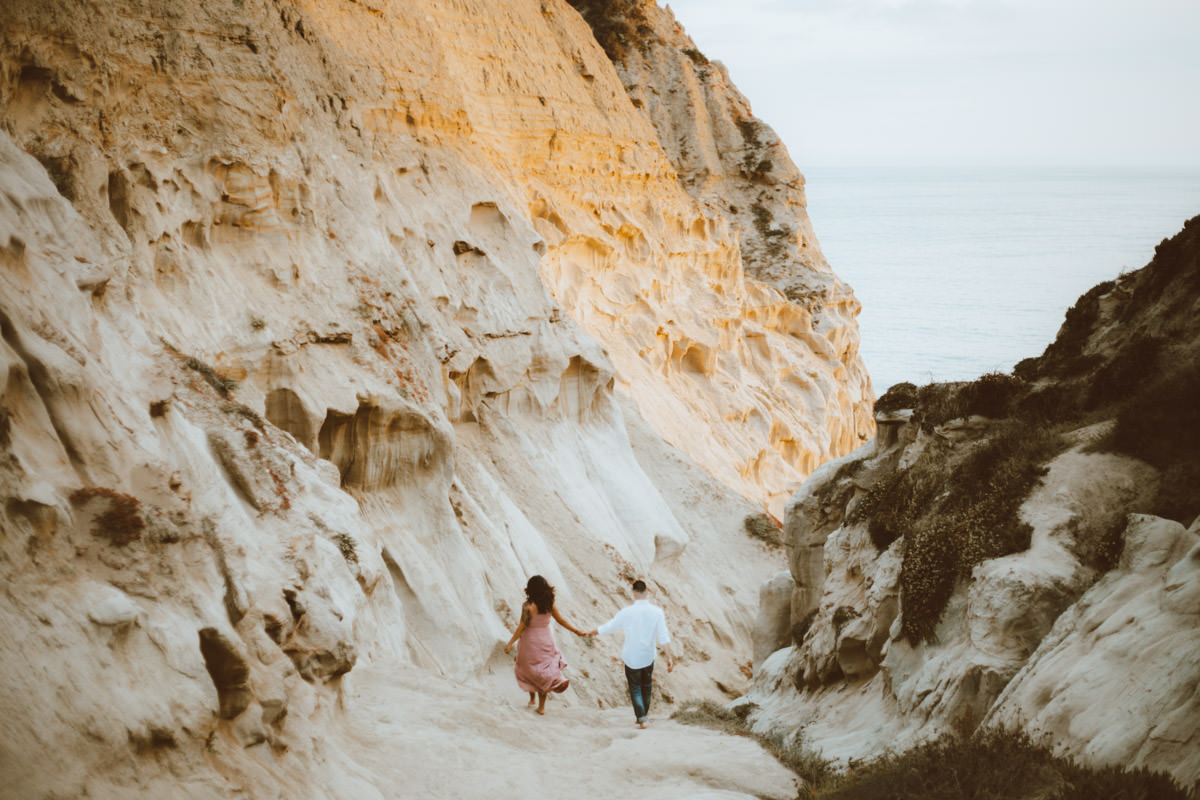 adventurous couple hiking barefoot for engagement session la jolla 15